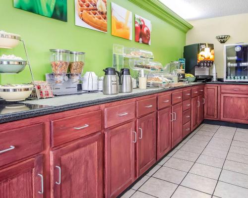 a kitchen with red wooden cabinets and a counter at Quality Inn in Franklin