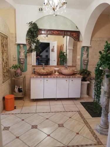 une salle de bain avec deux lavabos et un grand miroir dans l'établissement Clos Germanois, à Saint-Germain-Laval