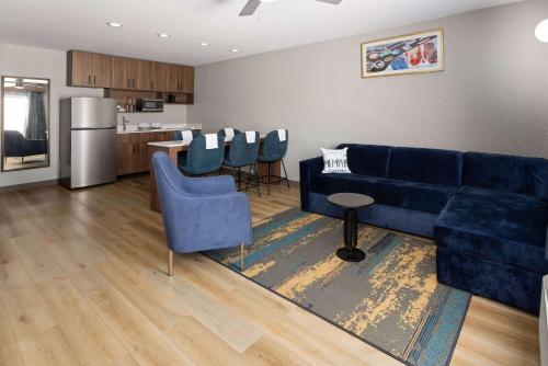 a living room with a blue couch and a kitchen at La Quinta Inn & Suites by Wyndham Memphis I-240 in Memphis