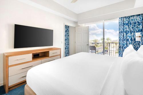 a bedroom with a bed and a flat screen tv at Hilton Vacation Club The Cove on Ormond Beach in Ormond Beach