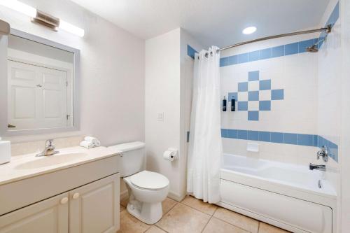 a bathroom with a white toilet and a sink and a tub at Hilton Vacation Club The Cove on Ormond Beach in Ormond Beach