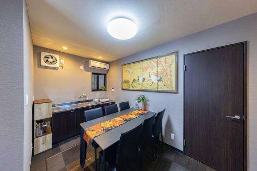 ein Esszimmer mit Tisch und eine Küche in der Unterkunft ぷらむならまち Sakura邸 in Nara