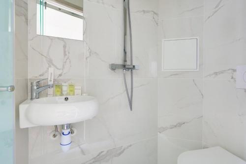 une salle de bain blanche avec un lavabo et des toilettes dans l'établissement Bluestay 289 - Superbe studio à Paris, à Paris