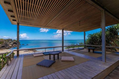 a wooden deck with a view of the ocean at villa serena in Yomitan