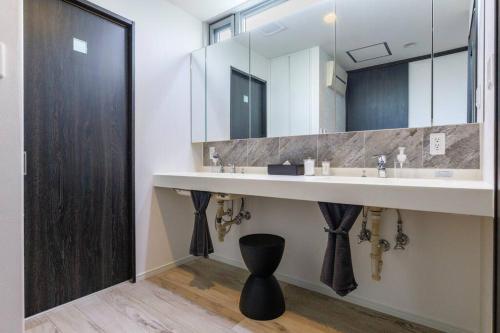 a bathroom with a sink and a large mirror at villa serena in Yomitan