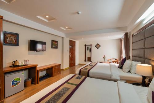 サパにあるBora Hotelのベッド2台とテレビがあるホテルの部屋