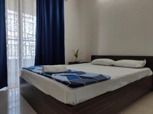 a bedroom with a bed with blue and white sheets at Modern 3BHK with Well-Equipped kitchen on 22 flr, Parking & Club House Perfect for Families in Bengaluru