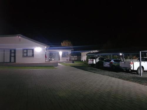 a house with two cars parked in front of it at night at MediStay Self Catering Accommodation in Bethlehem