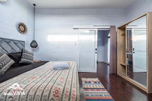 ein Schlafzimmer mit einem großen Bett und einem Spiegel in der Unterkunft Bingin Sun & Moon Wooden by Bukit Vista in Uluwatu