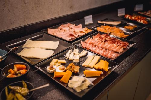 a buffet with many different types of cheese and meats at Hotel Ederstrand in Frankenberg