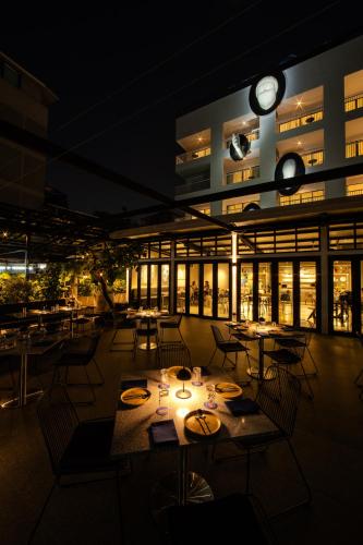 a restaurant with tables and chairs and a clock on a building at The StandardX, Bangkok Phra Arthit in Bangkok