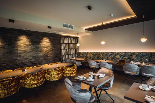 a restaurant with tables and chairs and a brick wall at Hotel Ederstrand in Frankenberg