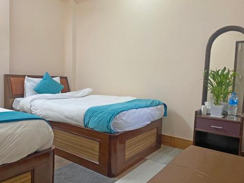 a bedroom with two beds and a mirror at Hotel Resunga Arjun in Kathmandu