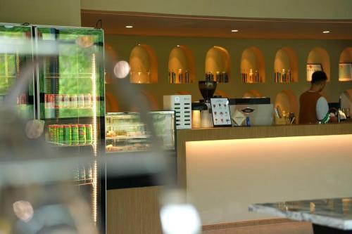 a restaurant with a bar with a counter and a person at 阿卡那拉橘子海亲子民宿 in Dapeng