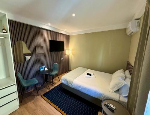 a hotel room with a bed and a small table at Lovely studio fully equipped near subway N7 in Lisbon