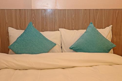 a bed with two green pillows on top of it at Hotel Resunga Arjun in Kathmandu