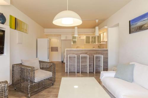 a living room with a couch and chairs and a kitchen at Agia Napa three bedroom modern flat in Ayia Napa