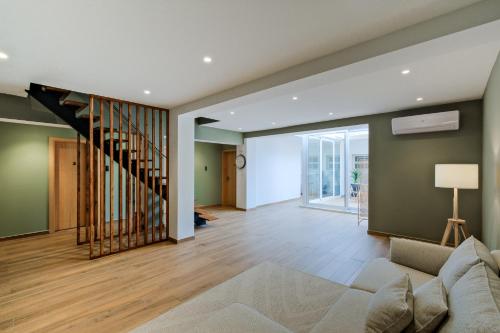 a living room with a couch and a staircase at Lovely studio fully equipped near subway N7 in Lisbon