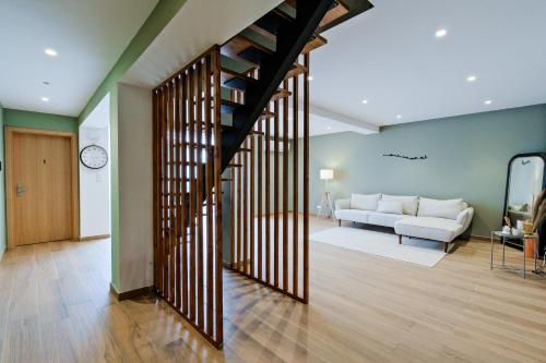 a living room with a spiral staircase and a couch at Lovely studio fully equipped near subway N7 in Lisbon