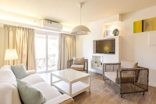 a living room with a couch and chairs and a tv at Agia Napa three bedroom modern flat in Ayia Napa