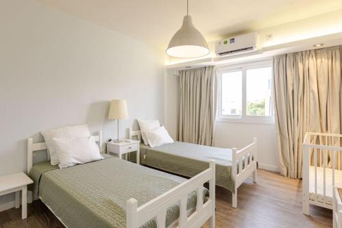 a small bedroom with two beds and a window at Agia Napa three bedroom modern flat in Ayia Napa