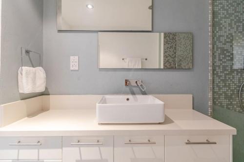 a bathroom with a white sink and a mirror at Agia Napa three bedroom modern flat in Ayia Napa