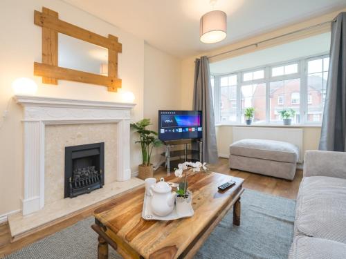 a living room with a fireplace and a couch at 3 bedroom detached homesleeps 5 in Shrewsbury - Pass the Keys in Bicton