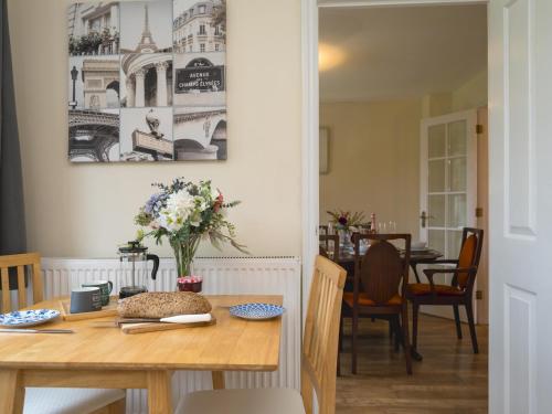 a dining room with a wooden table and a dining room table at 3 bedroom detached homesleeps 5 in Shrewsbury - Pass the Keys in Bicton
