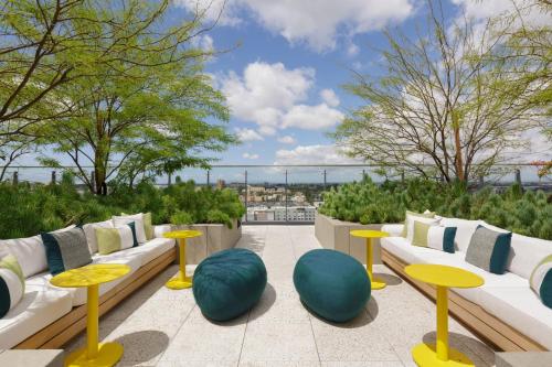 a patio with tables and couches on a roof at The Viv Hotel, Anaheim, a Tribute Portfolio Hotel in Anaheim
