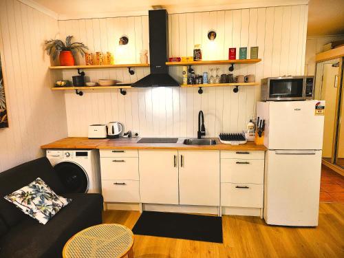 a kitchen with white cabinets and a white refrigerator at Deluxe Private Apartment- In Ramada Resort - Full Kitchen - in Port Douglas