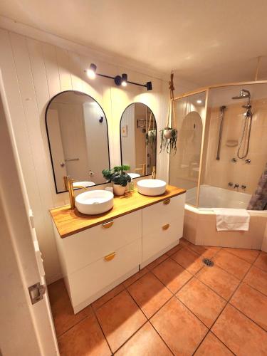 a bathroom with two sinks and a tub at Deluxe Private Apartment- In Ramada Resort - Full Kitchen - in Port Douglas