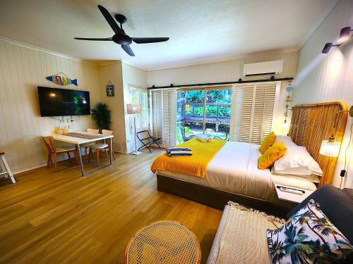 a bedroom with a bed and a desk and a window at Deluxe Private Apartment- In Ramada Resort - Full Kitchen - in Port Douglas