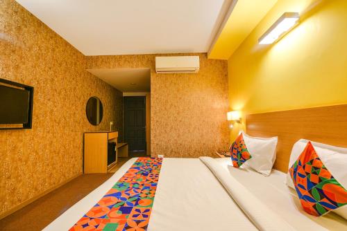a hotel room with a bed and a flat screen tv at Fabhotel Old Meple Leaf- Golf Course Road & Sector 27 in Gurgaon