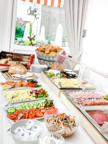 Una línea de buffet con muchos tipos diferentes de comida. en bei Kliewe im Westfälischen Hof, en Beckum