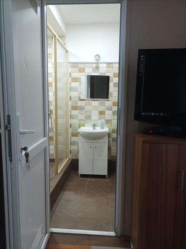 a bathroom with a sink and a mirror at Mátyás Pizzéria, Étterem és Vendégház in Balkány