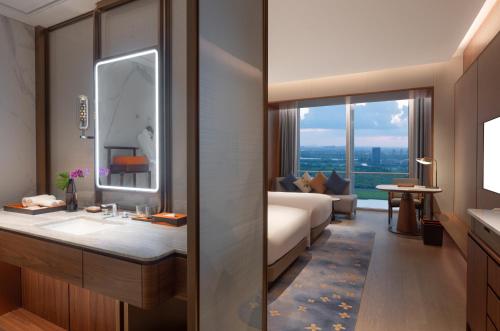 a bathroom with a sink and a bed and a mirror at Suzhou International Conference Hotel in Suzhou