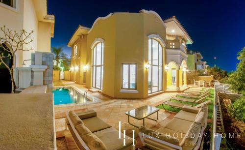 a villa with a swimming pool and a house at LUX - The Ocean Pearl Villa in Dubai
