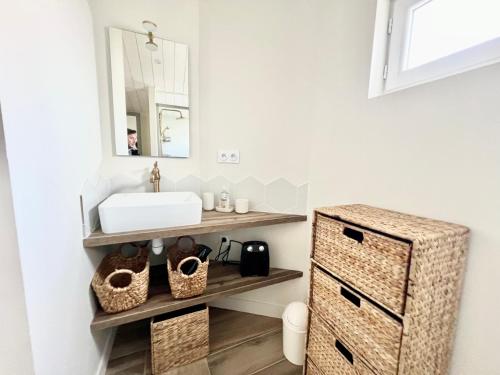 a bathroom with a sink and a mirror at Charmante Maison de Ville - Patio - Wifi - Parking gratuit in La Rochelle