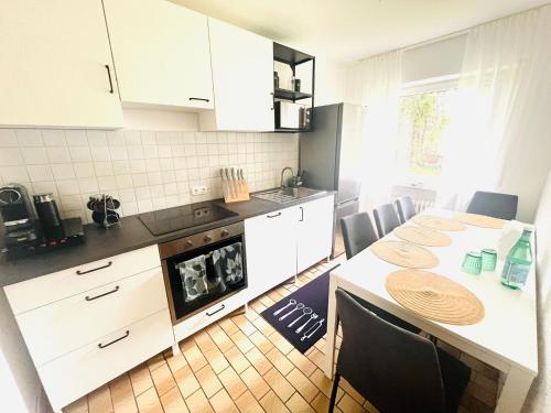 a kitchen with white cabinets and a table with a dog at Ferienwohnung Mendig in Mendig