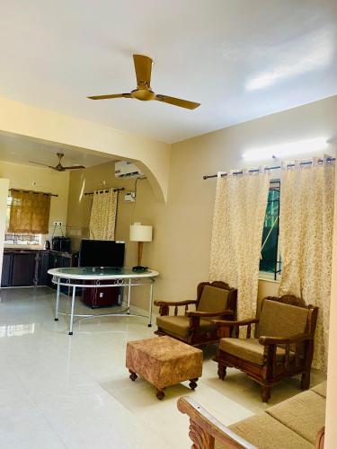 a living room with a ceiling fan and a table and chairs at Nasya Beachside Cottages in Benaulim