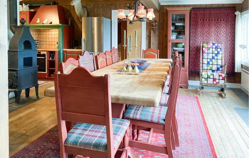 Un comedor con una larga mesa de madera y sillas. en Nice Home In Oppdal With Sauna, en Oppdal