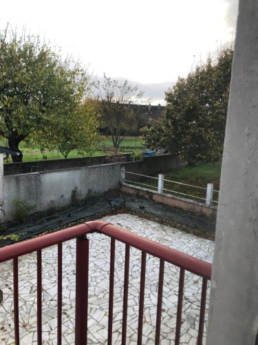 un balcon avec une clôture et des arbres dans un parc dans l'établissement Grande chambre côté jardin, à Château-du-Loir
