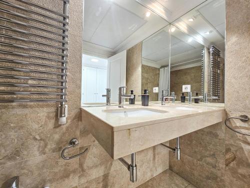 a bathroom with a sink and a large mirror at Apartamentos Zaragoza Independencia 3000 in Zaragoza