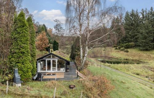 una pequeña casa con techo de hierba en Nice Home In Hobro With Sauna, en Hobro