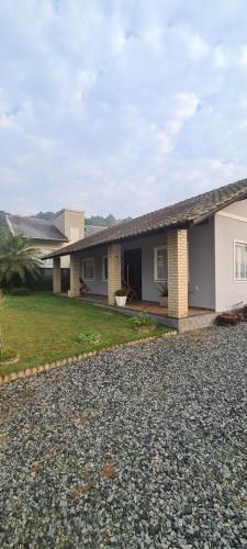 a house with a gravel driveway in front of it at Casa aconchegante em Pomerode in Pomerode