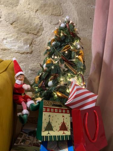 Un arbre de Noël avec des cadeaux et un elf assis à côté dans l'établissement Charming apartment - Marais Quarter - 5P - 2BDR - Center of Paris, à Paris