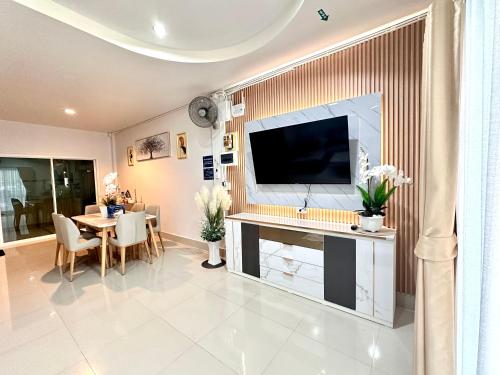 a living room with a television and a dining room at Dream Homestay Hat Yai in Sathani Khlong Rian
