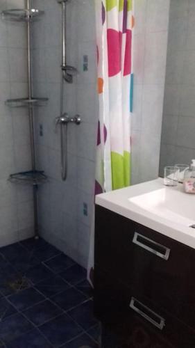 La salle de bains est pourvue d'une douche avec un lavabo et un rideau de douche. dans l'établissement Maison à 50 m de la plage, à Banyuls-sur-Mer