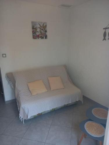 - un lit dans l'angle d'une pièce avec deux tabourets dans l'établissement Maison à 50 m de la plage, à Banyuls-sur-Mer