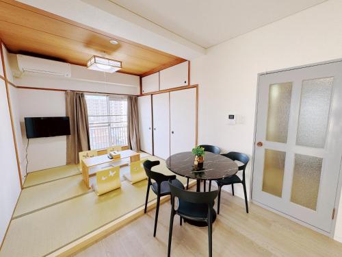 a dining room with a table and chairs in a room at 嵐 Arashi BNB 難波西 No8112 in Osaka